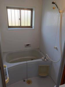 a bathroom with a bath tub and a window at つるふく in Misaki +14 photos