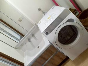 a white washing machine sitting next to a refrigerator at つるふく in Misaki