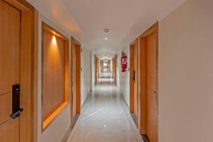 a hallway with wooden doors and a long corridor at Treebo Shree Krishna Palace in Ahmedabad