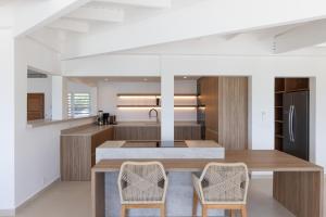 a kitchen with a large island with two chairs at O SUN in Les Terres Basses