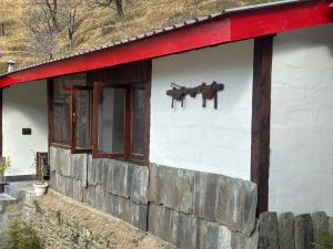 a white building with a red roof and windows at The Himalayan Home in Nagar