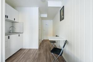 a kitchen with a table and a chair in a room at Rygge Apartments in Moss