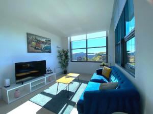 a living room with a blue couch and a tv at Modern 2-Bed Apartment in Blu Bracknell in Bracknell