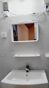 a mirror above a white sink in a bathroom at Econest arugambay in Arugam Bay