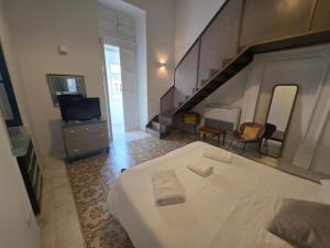 a bedroom with a large white bed and a staircase at Prime Fully Equipped Studio 2 Ideal Base to Explore Malta in Il-Furjana
