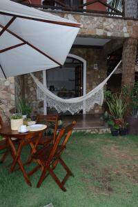 a patio with a table and chairs and an umbrella at Chalé em Condomínio com in Aracati