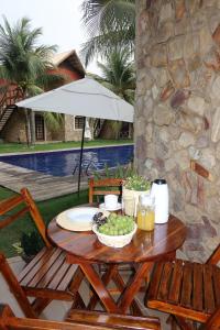 a table with a bowl of grapes on a patio at Chalé em Condomínio com in Aracati