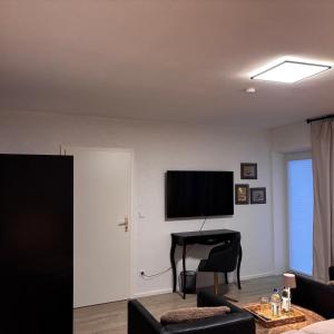 a living room with a flat screen tv and a table at Waldblick Glatt in Sulz am Neckar