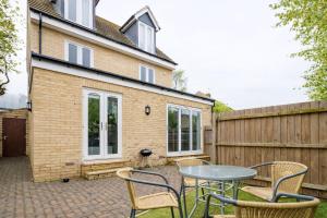 a patio with a table and chairs and a fence at TANZANITE - Ground Floor 2BR apart, Pet friendly in Cambridge