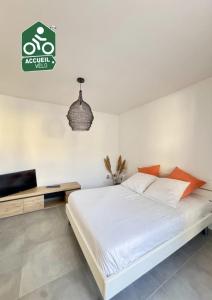 a white bedroom with a bed and a television at Hébergement neuf, centre-ville de Morestel - Résidence Boyraz in Morestel