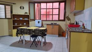a kitchen with a table and two stools at Kaza Manata in Praia +4 photos
