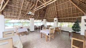 a restaurant with tables and chairs and a large ceiling at Seashore hotel and Eco Bungalow in Kumba Urembo