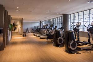 a gym with a row of treadmills and ellipticals at KOS Pilar Hotel in Pilar