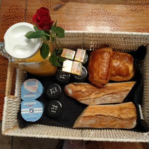 a tray of bread and pastries and a vase with a rose at La pause enchantee in Villarcoin