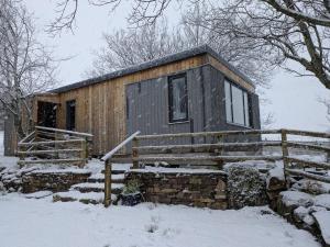 a small cabin in the snow in the woods at Pollan-Na Clach Cabin in Lairg