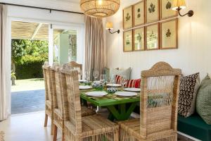 a dining room with a green table and chairs at Noordhoek Village Hotel in Noordhoek