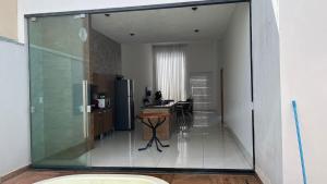 a kitchen with a glass wall and a table at Espaço verão in Santa Fé do Sul