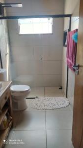 a bathroom with a toilet and a shower with a window at Espaço verão in Santa Fé do Sul +7 photos