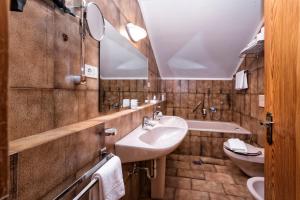 a bathroom with a sink and a mirror and a tub at Residence Tolderhof - Olang in Valdaora +41 photos