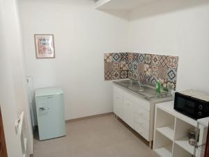 a small kitchen with a sink and a refrigerator at Penelope in Agrigento