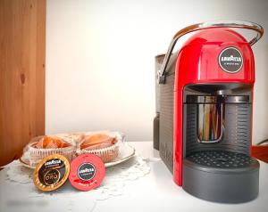 Una tostadora roja junto a dos cestas de pan. en Villa Etruria Guest House, en Pitigliano