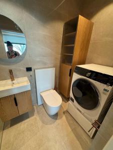 a small bathroom with a toilet and a washing machine at Apartment at NerSalberg Farm in Røra, Inderøy in Røra