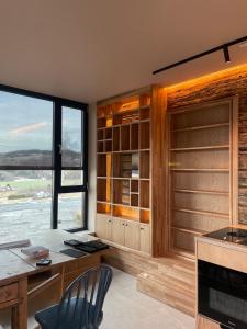 a kitchen with a desk and a large window at Apartment at NerSalberg Farm in Røra, Inderøy in Røra