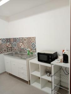 a kitchen with a sink and a microwave at Penelope in Agrigento