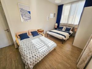 a bedroom with two beds and a chair in it at Beachfront Bliss 3 bedroom Privacy in Netanya