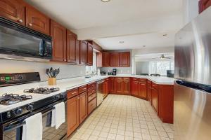 una cucina con mobili in legno e un forno a piano cottura di Kingswood Mountainside Retreat a White River Junction