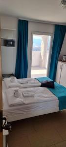 a bedroom with a large bed with a window at Apartments Matteo in Omišalj