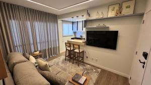 a living room with a couch and a flat screen tv at Apartamento palmas in Palmas
