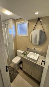 a bathroom with a sink and a toilet and a mirror at Apartamento palmas in Palmas