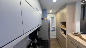a small kitchen with a refrigerator and a hallway at Apartamento palmas in Palmas