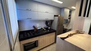 a small kitchen with a stove and a refrigerator at Apartamento palmas in Palmas