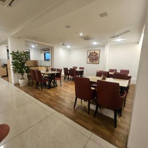 a restaurant with tables and chairs in a room at Stae Residency Hitec City in Hyderabad