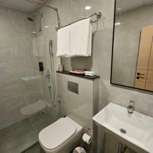 a bathroom with a shower and a toilet and a sink at Stae Residency Hitec City in Hyderabad +10 photos