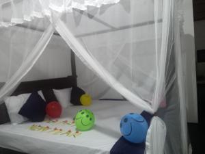 a bed with three balls sitting on top of it at Venus Inn Goyambokka in Tangalle