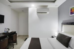 a bedroom with a bed and a desk and a bed sidx sidx sidx at Comfy Stay Hotels 2nd Floor in New Delhi