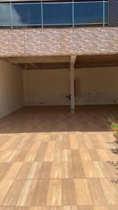 una stanza vuota con un pavimento in legno di fronte a un edificio di Casa temporada em Perocão a Guarapari