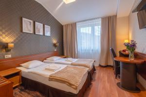 a hotel room with two beds and a table at Centrum Green Hill Business & SPA in Wisła +49 photos