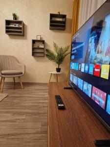 een televisiescherm met afstandsbediening op een tafel bij Helia Apartment in Galaţi