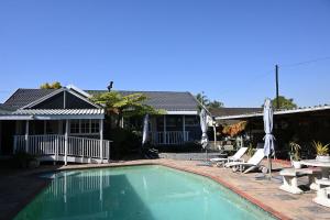 a swimming pool in front of a house at Matts Rest Bnb & Self-catering in Pietermaritzburg