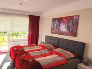 een slaapkamer met een bed met een rode deken bij Hotel Georgenhöhe Wildemann in Wildemann
