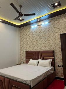 a bedroom with a bed with a ceiling fan at Green Valley Residency in Lucknow
