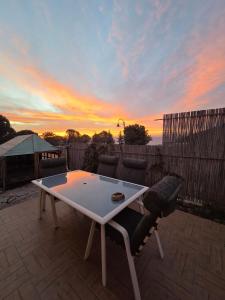 een tafel en stoelen op een patio met een zonsondergang bij פסטרנק אירוח יער אודם in Odem +18 foto's