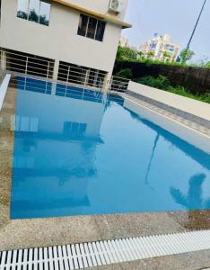 a large blue swimming pool in front of a house at Sunset stay in Daman