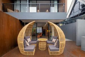 eine Terrasse mit zwei Korbstühlen und einem Tisch in der Unterkunft Northpine Cottages in Tegalharendong