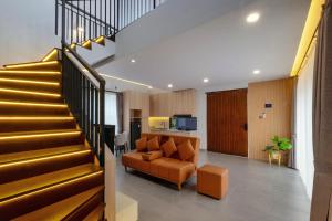 ein Wohnzimmer mit Sofa und Treppe in der Unterkunft Northpine Cottages in Tegalharendong