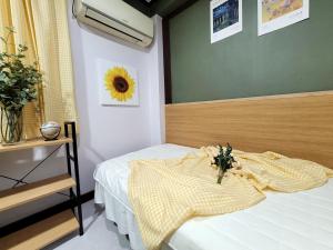 a bedroom with a bed with a sunflower on the wall at 더스테이365 디럭스 in Seoul